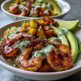 Fresh mango salsa adds color to smoky grilled shrimp and avocado, with lime chili sauce drizzled over a nutritious quinoa bowl.