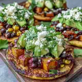 Golden caramelized sweet potatoes seasoned with cumin and smoked paprika, layered over warm black bean and corn mixture on a crunchy tostada base.