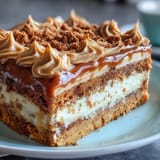 Moist Decadent Baked Biscoff Cake with Creamy Lotus Frosting, featuring a rich swirl of lotus spread and golden crumb on a marble countertop.
