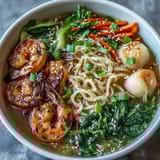 Asian Noodle Bowl with Shrimp and Scallops, brimming with tender seafood, crisp vegetables, and aromatic broth in a steaming bowl.
