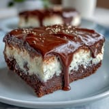 A vanilla sponge graduation cake topped with silky white chocolate buttercream and festive gold balloon decorations for a milestone celebration.