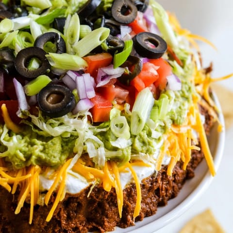 Homemade Seven-Layer Dip: a colorful photo of Tex-Mex flavors with a fresh salsa topping.