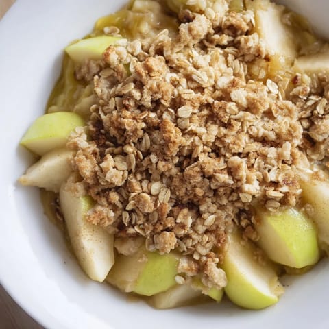 Golden brown apple crumble with bubbling fruit, perfect for a cozy dessert after dinner.