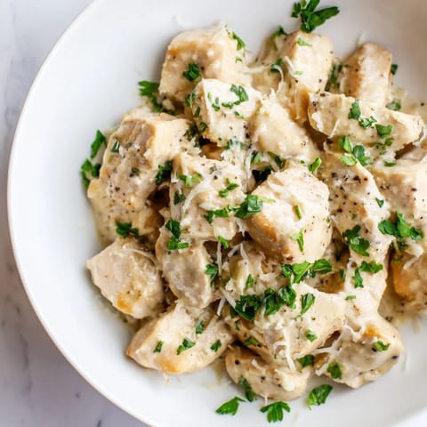 Fresh parsley garnish crowns tender Creamy Garlic Chicken Bites served alongside creamy mashed potatoes for a cozy meal.