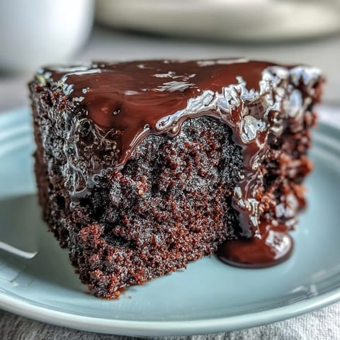 Freshly baked Easy Chocolate Fudge Cake layers cooling on a wire rack, revealing a moist, tender crumb before being frosted.