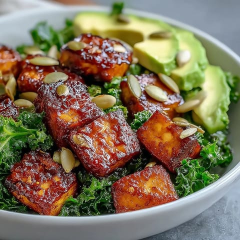 Protein-packed tofu and kale bowl topped with fresh avocado, green onions, and a sprinkle of nutritional yeast for extra flavor.  