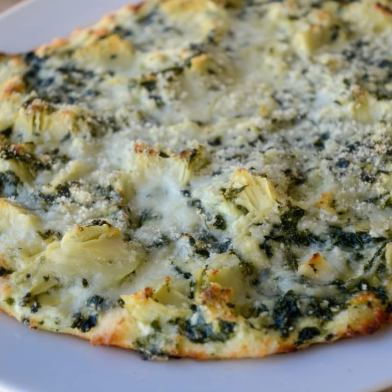 A close-up of Spinach Artichoke Dip, rich cheese pulls, perfect for a party appetizer with friends.