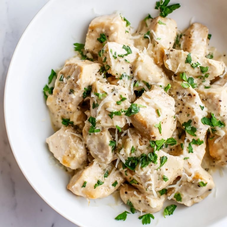 Fresh parsley garnish crowns tender Creamy Garlic Chicken Bites served alongside creamy mashed potatoes for a cozy meal.