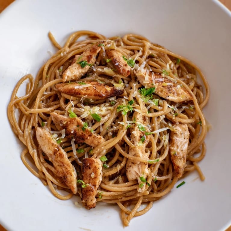 Bright, citrusy Brown Butter Lemon Chicken Pasta plated with Parmesan and parsley, garnished with a lemon wedge for a fresh finish.